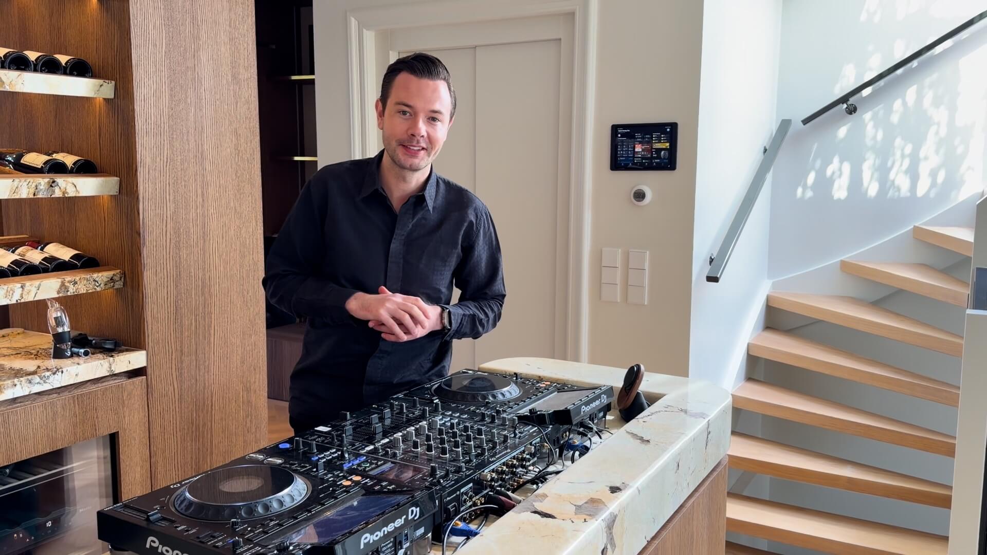Sam Feldt standing behind a Pioneer DJ setup in his Amsterdam home
